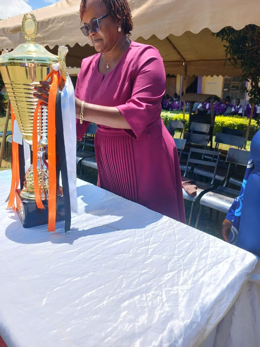 A school leader adjusting the trophy ribbons